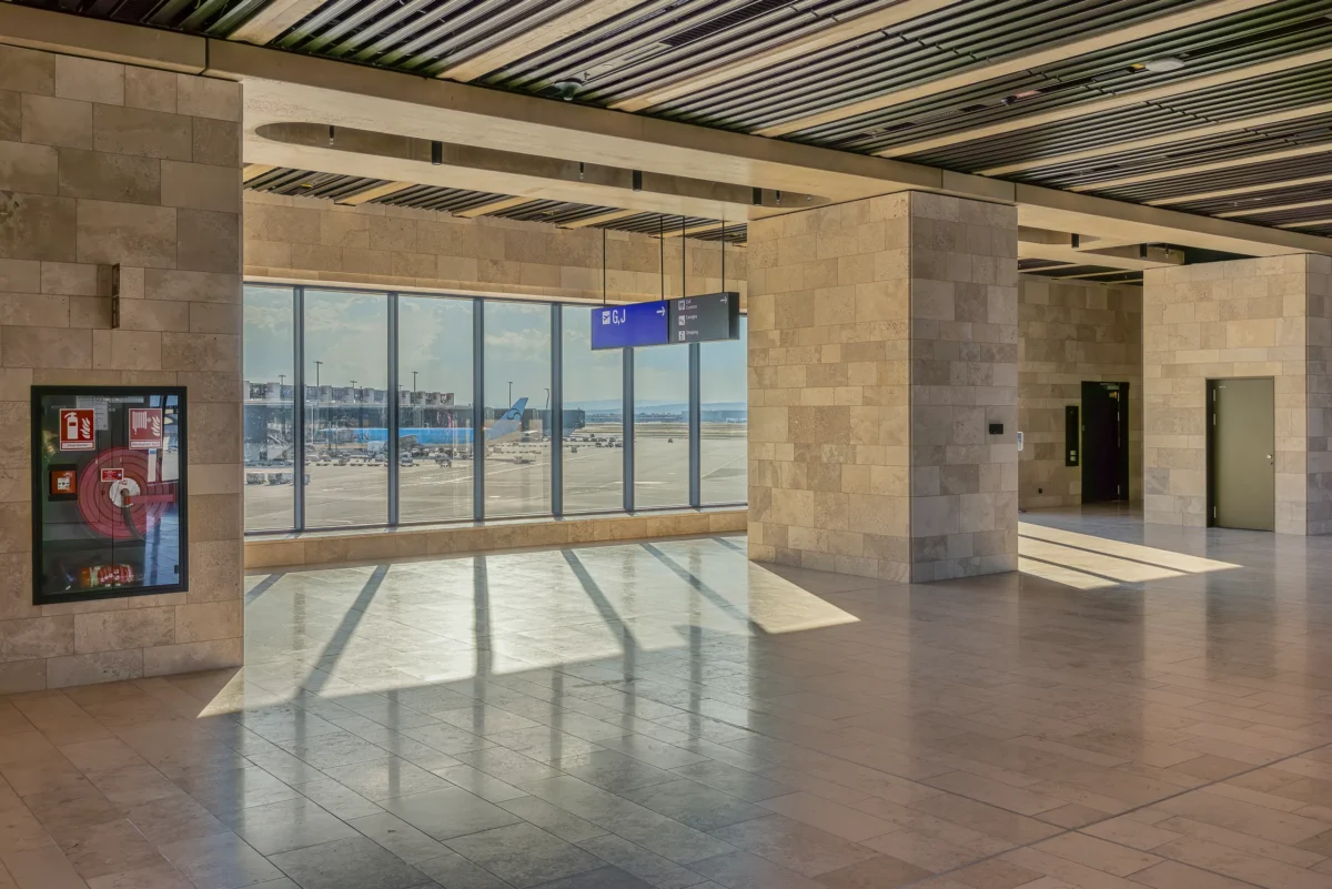 Gatebereich im Terminal 3 mit Panoramafenster zum Vorfeld und Wandpfeilern aus Travertin