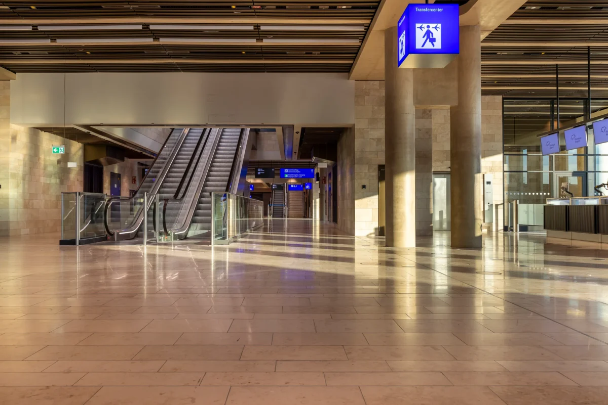Transfercenter im Terminal 3 mit Rolltreppenanlage und travertinverkleideten Saeulen